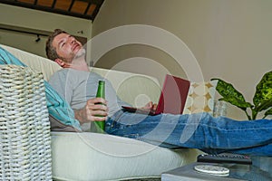 Lifestyle indoors portrait of young attractive and handsome happy man sitting at home sofa couch working online with laptop comput