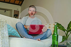 Lifestyle indoors portrait of young attractive and handsome happy man sitting at home sofa couch working online with laptop comput