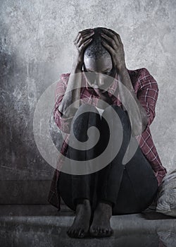 lifestyle indoors portrait of young sad and depressed black african American woman sitting at home floor feeling desperate and