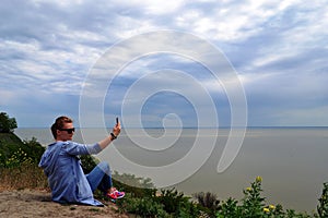 Lifestyle, leisure, summer, technology and people concept - smiling young woman or teenage girl in sun hat taking selfie with