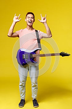 Lifestyle, leisure and youth concept. Vertical portrait of asian man in stylish outfit, perfoming, holding blue electric