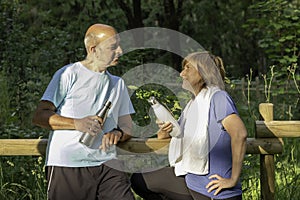 Daily lifestyle of mature couple standing in the park after a clss of yoga together spending quality time