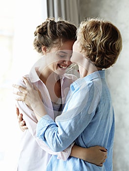 Lifestyle and people concept - Beautiful senior mom and her adult daughter are hugging, looking at camera and smiling.