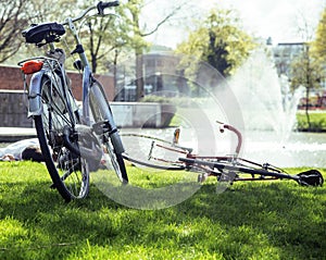 Lifestyle people concept: couple of bicycle on green grass in summer park at fountain