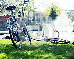 lifestyle people concept: couple of bicycle on green grass in summer park at fountain close up