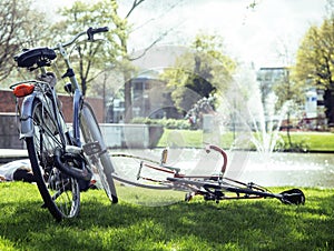 Lifestyle people concept: couple of bicycle on green grass in summer park at fountain