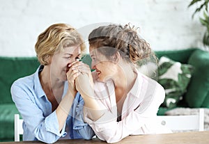 Lifestyle and people concept: Senior Woman With Adult Daughter Relaxing On Sofa At Home