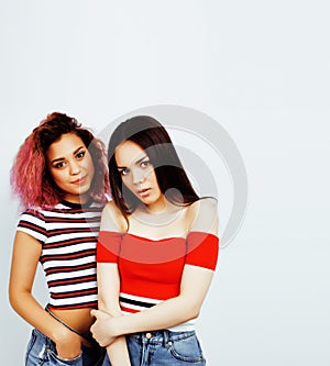 lifestyle people concept: two pretty stylish modern hipster teen girl having fun together, diverse nation mixed races