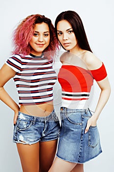 Lifestyle people concept: two pretty stylish modern hipster teen girl having fun together, diverse nation mixed races