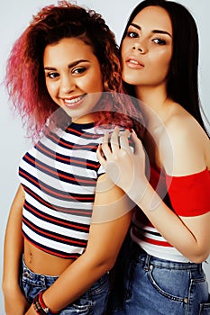 Lifestyle people concept: two pretty stylish modern hipster teen girl having fun together, diverse nation mixed races