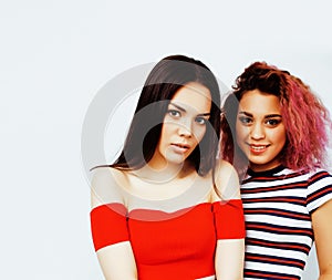 Lifestyle people concept: two pretty stylish modern hipster teen girls having fun together, diverse nation mixed races