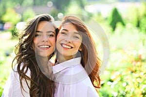 Lifestyle and people concept. Young girl friends standing together and having fun in spring park.