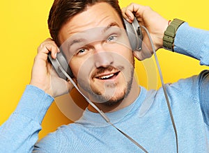 Lifestyle and people concept: young man listening to music with