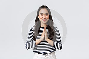 Lifestyle, people emotions and casual concept. Cute asian girl in casual outfit smiling as saying namaste, holding hands