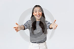 Lifestyle, people emotions and casual concept. Friendly charming asian girl reaching hands forward to hold something