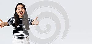 Lifestyle, people emotions and casual concept. Friendly charming asian girl reaching hands forward to hold something