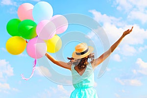 Lifestyle photo happy woman with an air colorful balloons is enjoying a summer day on blue sky background