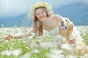 Lifestyle photo of a happy young girl with her pet dog Labrador Retriever in nature.