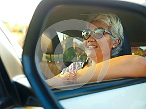 Lifestyle portrait of attractive and happy middle aged Asian Indonesian woman 40s or 50s  with grey hair and beautiful smile