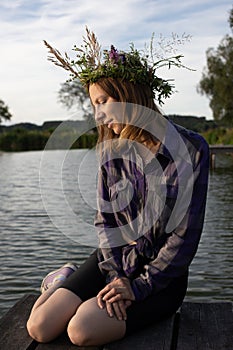 lifestyle portrait of a beautiful woman in a wreath of wildflowers. Summer holiday of Ivan Kupala