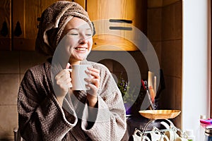 Lifestyle portrait of a beautiful young girl drinking morning coffee in her kitchen