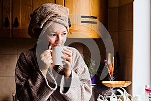 Lifestyle portrait of a beautiful young girl drinking morning coffee in her kitchen