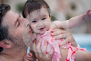 lifestyle portrait of father and little daughter enjoying summer - man holding her sweet baby girl excited and cheerful playing