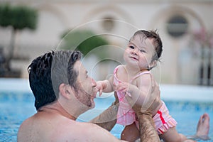 lifestyle portrait of father and little daughter enjoying summer - man holding her sweet baby girl excited and cheerful playing