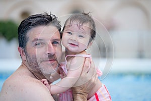 lifestyle portrait of father and little daughter enjoying summer - man holding her sweet baby girl excited and cheerful playing