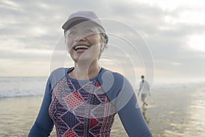 Lifestyle portrait of fit and happy middle aged woman after beach running workout - 40s or 50s attractive mature lady with grey