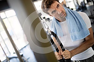 Lifestyle portrait of handsome muscular man after the training in the sport gym