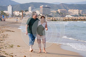 Lifestyle portrait of loving happy and sweet mature couple - senior retired husband and wife on 70s enjoying beach walk relaxed