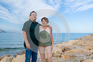 Lifestyle portrait of loving happy and sweet mature couple - senior retired husband and wife on 70s enjoying beach walk relaxed