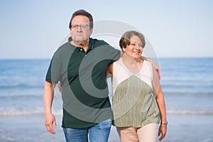 Lifestyle portrait of loving happy and sweet mature couple - senior retired husband and wife on 70s enjoying beach walk relaxed