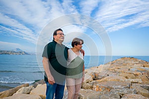 Lifestyle portrait of loving happy and sweet mature couple - senior retired husband and wife on 70s enjoying beach walk relaxed