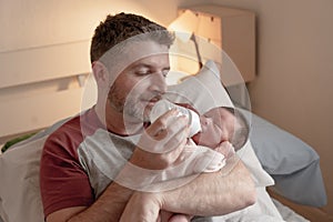 Lifestyle portrait of proud happy man holding tenderly bottle feeding her child - an adorable and beautiful newborn baby girl in