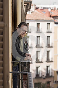 Lifestyle portrait of sad and depressed mature man 65 to 70 years old at home balcony feeling lonely and confused facing getting