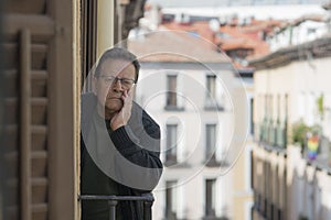 Lifestyle portrait of sad and depressed mature man 65 to 70 years old at home balcony feeling lonely and confused facing getting