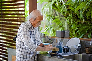 lifestyle portrait of senior happy and sweet Asian Japanese retired man cooking at home kitchen alone neat