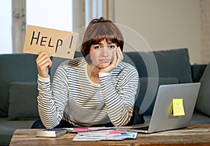 Lifestyle portrait of stressed and overwhelmed young woman accounting home finances paying bills