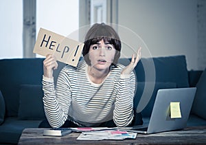 Lifestyle portrait of stressed and overwhelmed young woman accounting home finances paying bills