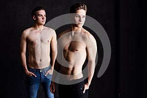 Lifestyle portrait of two handsome boys tween brothers posing topless in loft studio