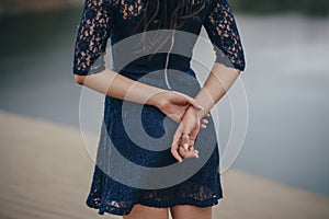 Lifestyle portrait of a woman brunette on the background of the lake in the sand on a cloudy day. Romantic, gentle, mystical