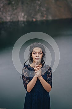 Lifestyle portrait of a woman brunette on the background of the lake in the sand on a cloudy day. Romantic, gentle, mystical