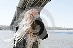 Lifestyle portrait of young adult female on a beach with flying hair