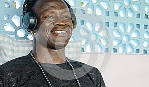 Lifestyle portrait of young attractive and happy cool black African American man smiling cheerful listening to music on yellow