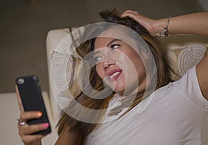 Lifestyle portrait of young attractive happy and relaxed woman enjoying homey at living room sofa couch using internet social