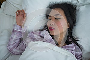 Lifestyle portrait of young beautiful and sweet Asian Korean girl on her 20s alone at home sleeping relaxed wearing pajamas lying