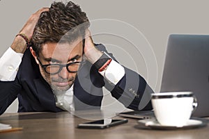 Lifestyle portrait of young exhausted and sleepy business man feeling wasted and hangover working lazy on Monday at computer desk