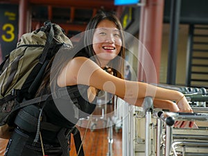 Lifestyle portrait of young happy and attractive Asian Korean woman with backpack smiling excited and playful at airport arrival